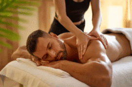 massagem-tantrica-toque-consciente.jpg Profissional de massagem tântrica tocando as costas de um cliente de forma delicada e respeitosa em um ambiente sereno e iluminado, representando o toque consciente.