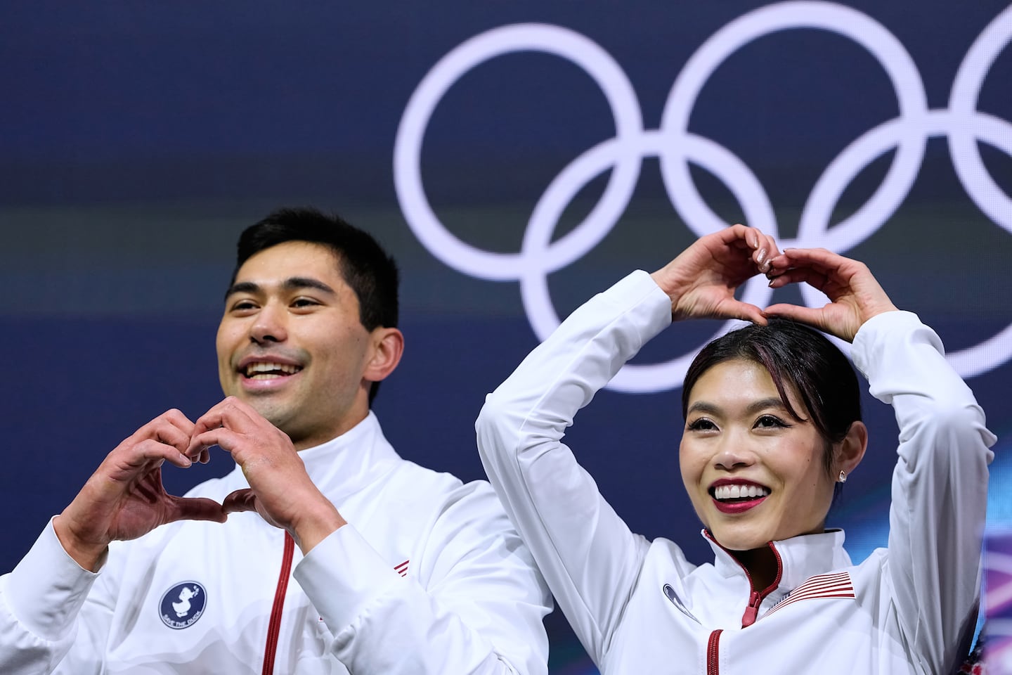 Emily Chan (right) and Spencer Akira Howe of the United States react to their scores after  pairs short program Sunday.