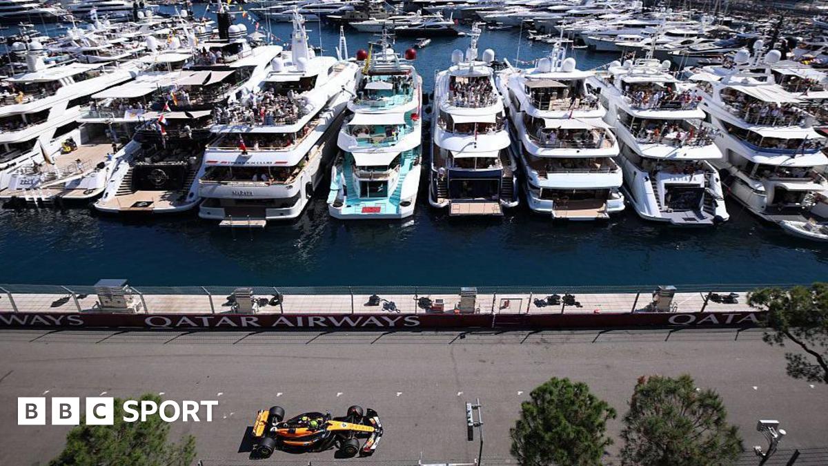 Lando Norris on track in Monaco drives past yachts in the harbour